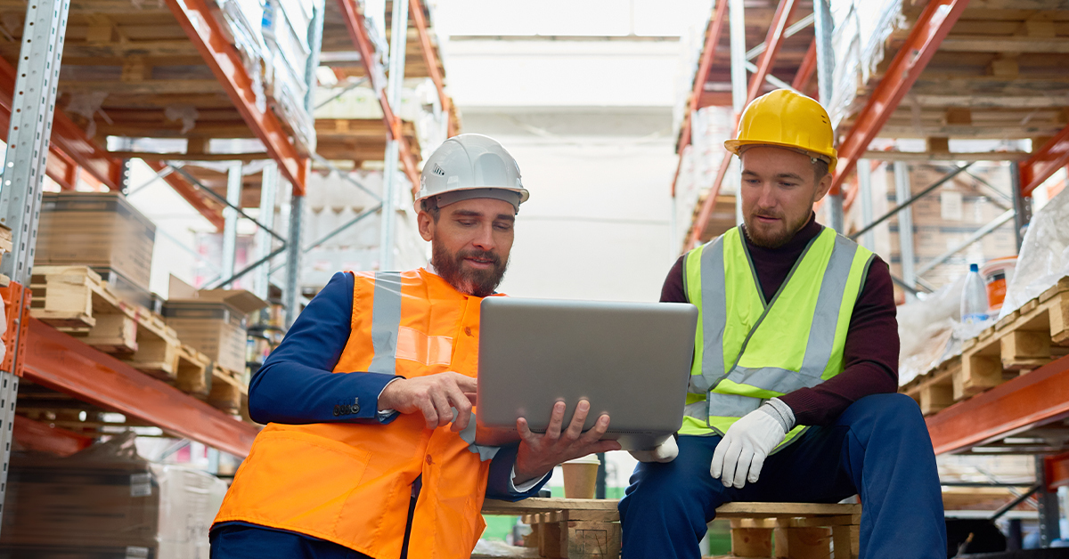 warehouse workers looking at laptop