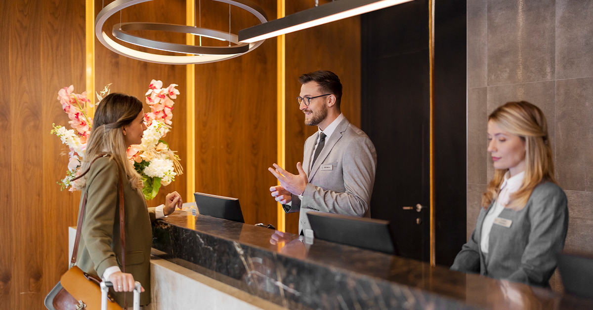 woman checking into the front desk of a hotel